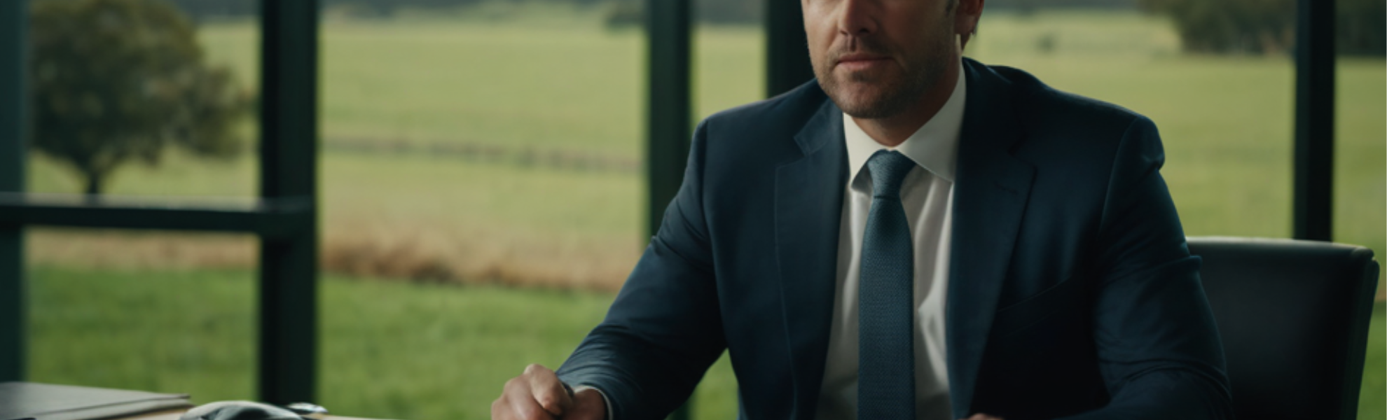 home loan broker sitting at desk in front of large window